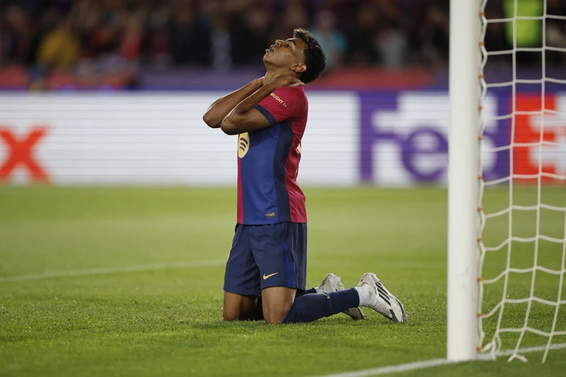 lesion de lamine yamal: imagen ilustrativa de un futbolista del FC Barcelona arrodillado en el césped con gesto de dolor junto al poste de la portería