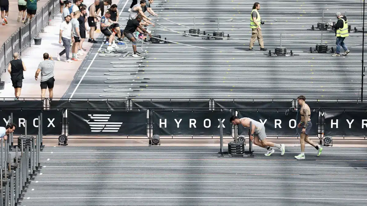 Atletas desplazando trineos durante una competición HYROX en pista cubierta