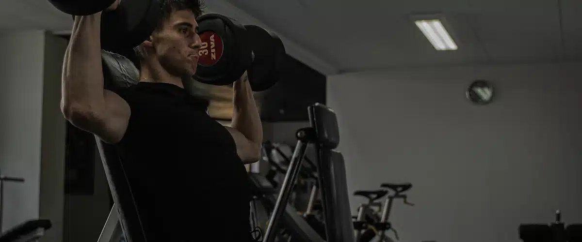 Deportista realizando ejercicios con pesas para preservar la fuerza muscular