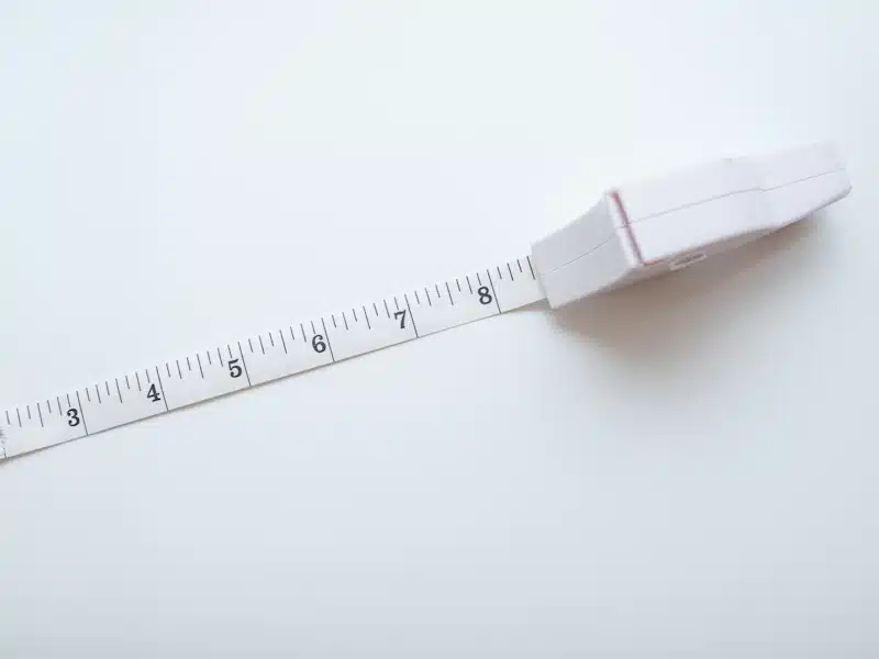 Cinta métrica extendida sobre superficie clara para registrar medidas físicas