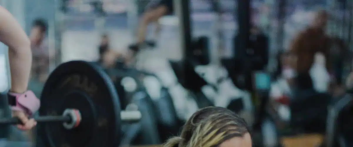 Deportista realizando un levantamiento con barra durante entrenamiento de fuerza