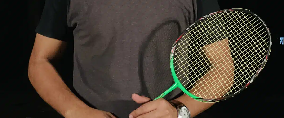 Jugador sujetando una raqueta de tenis con ambas manos antes de entrenar