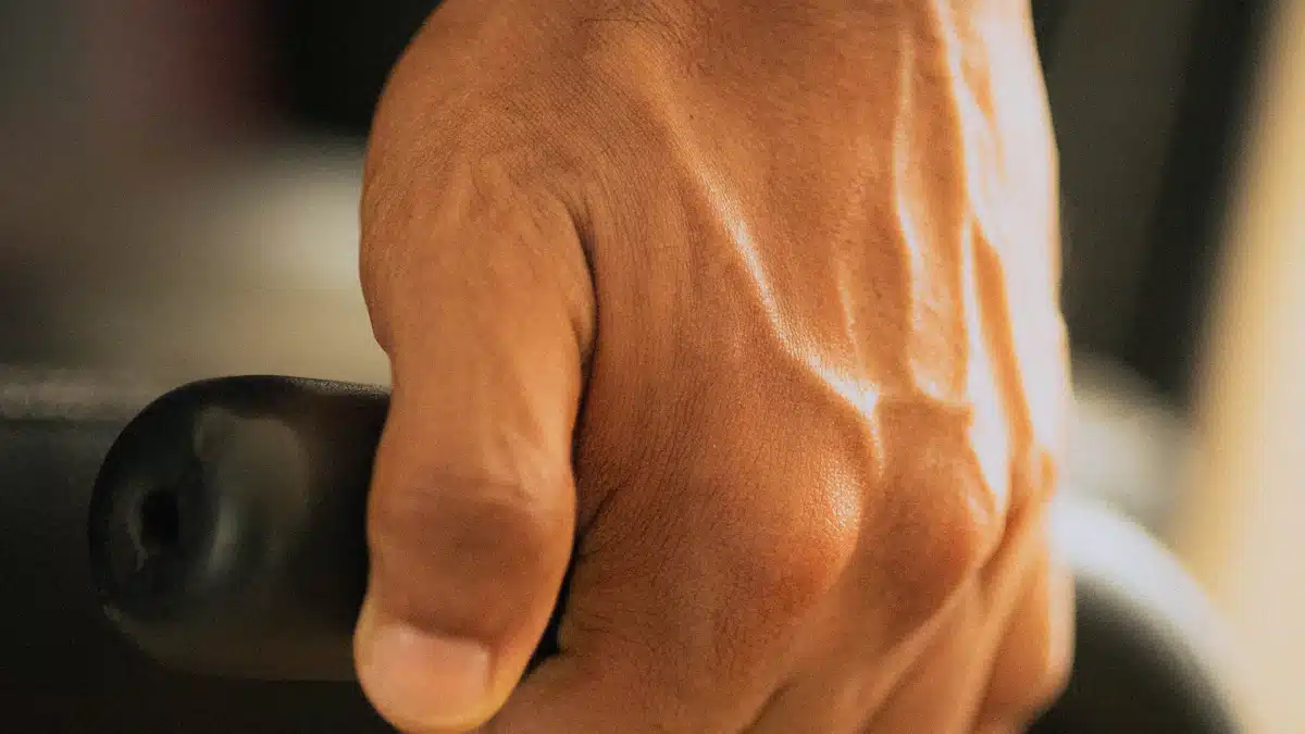 Primer plano de una mano sujetando una empuñadura durante entrenamiento de fuerza