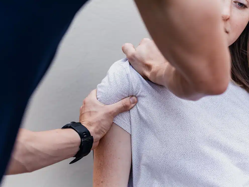 Profesional de fisioterapia trabajando sobre el brazo de una persona en consulta