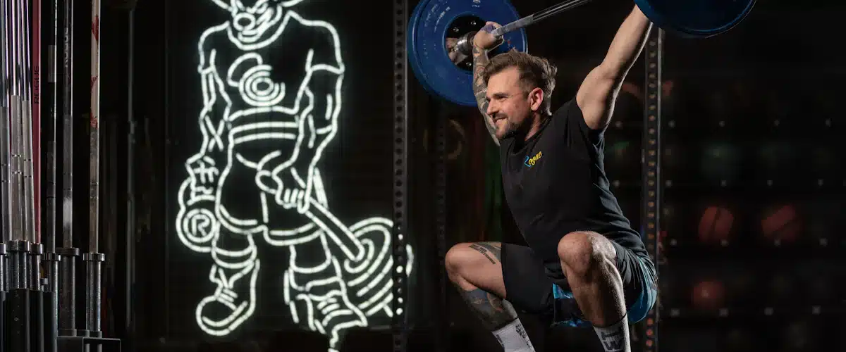 Atleta entrena una sentadilla con barra durante una sesión de fuerza