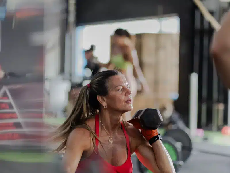 Atleta realizando ejercicio con mancuerna durante una sesión de fuerza