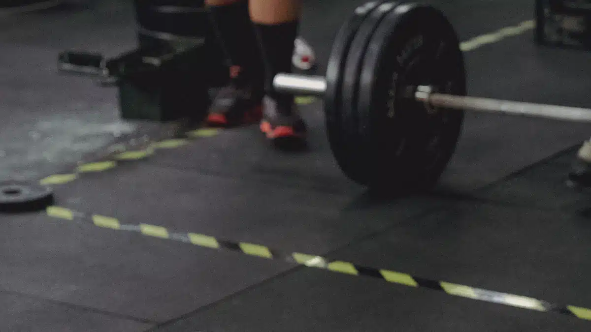 Barra olímpica y discos de entrenamiento preparados en un gimnasio