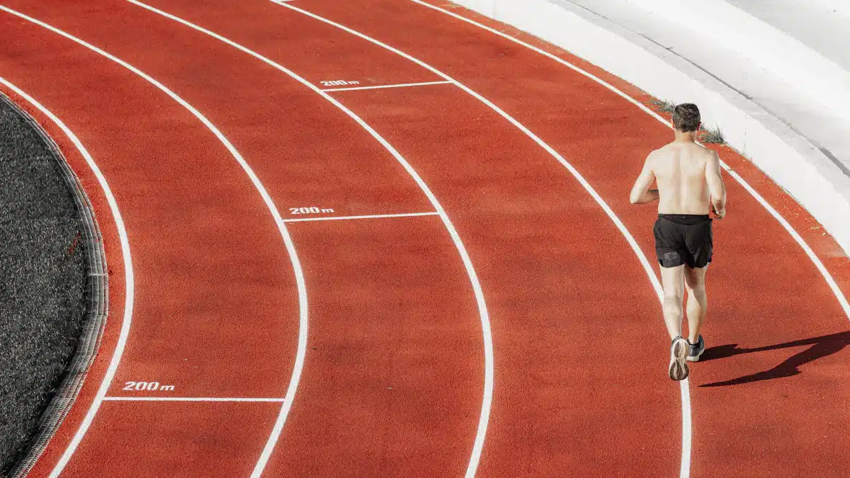 Corredor entrenando en pista roja para mejorar su capacidad aeróbica