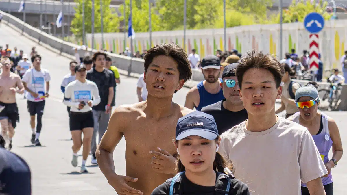Corredores recogiendo agua en un punto de hidratación de una maratón