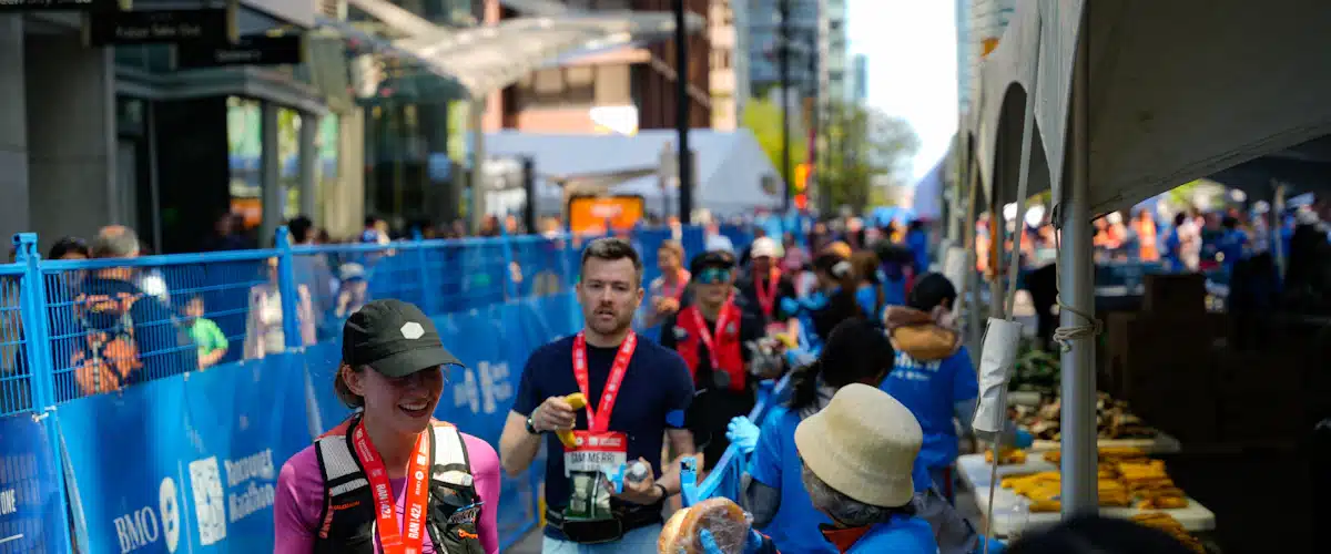Corredores recogiendo bebidas y alimentos para recuperarse después de una carrera