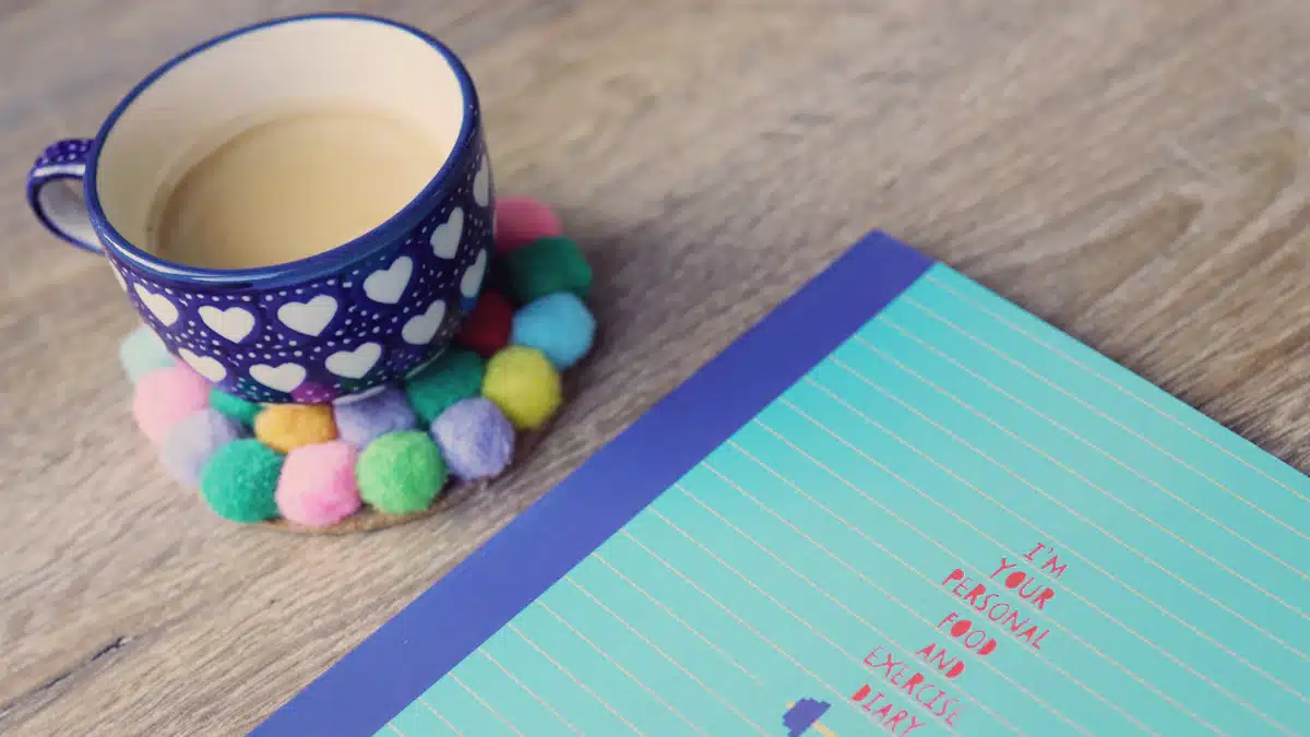 Cuaderno de planificación junto a una taza sobre una mesa
