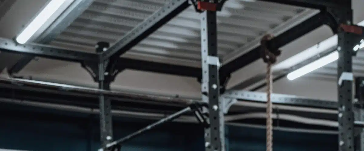 Deportista ejecuta una sentadilla con barra en un gimnasio equipado