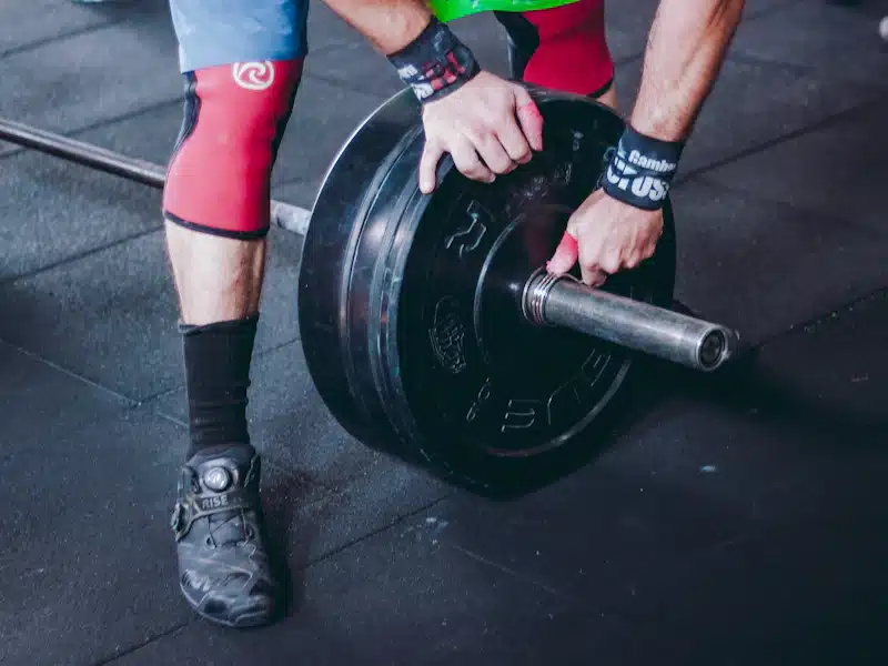 Deportista levantando una barra olímpica en un box de entrenamiento