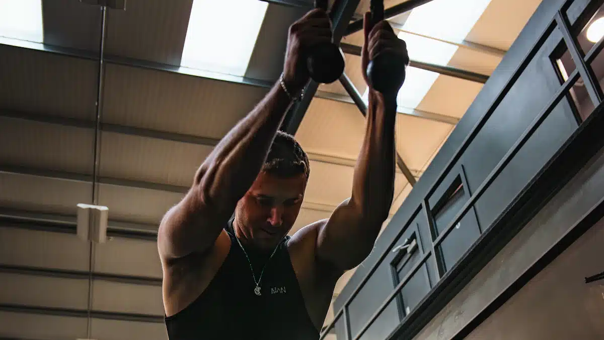 Deportista realizando dominadas en una barra de entrenamiento funcional del gimnasio