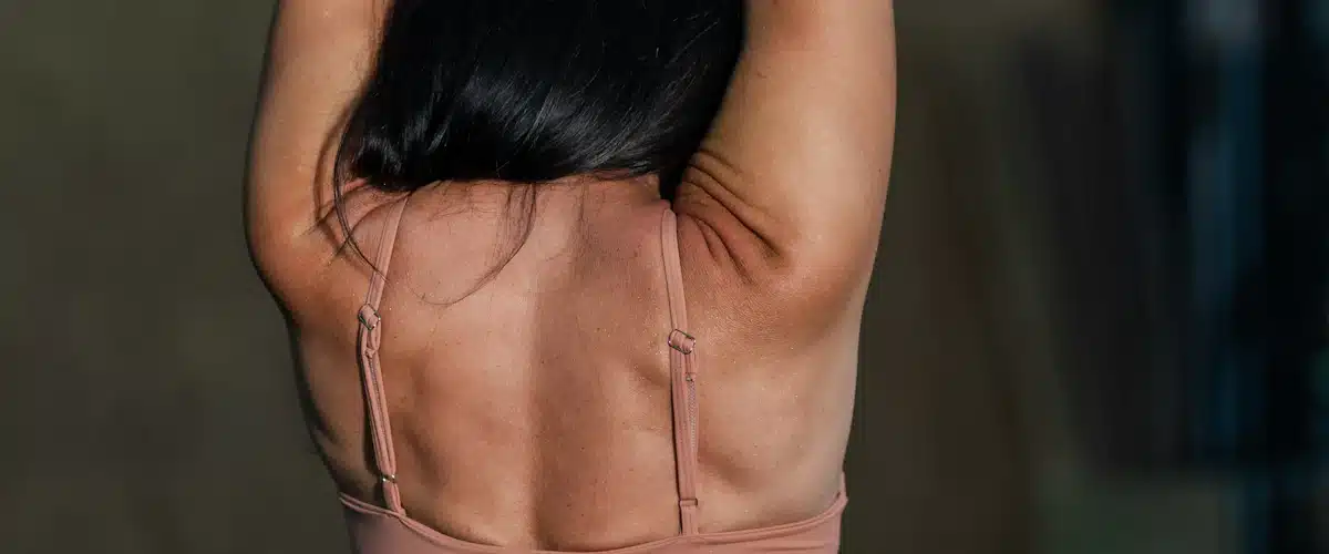 Deportista trabaja movilidad de hombros elevando ambos brazos en gimnasio