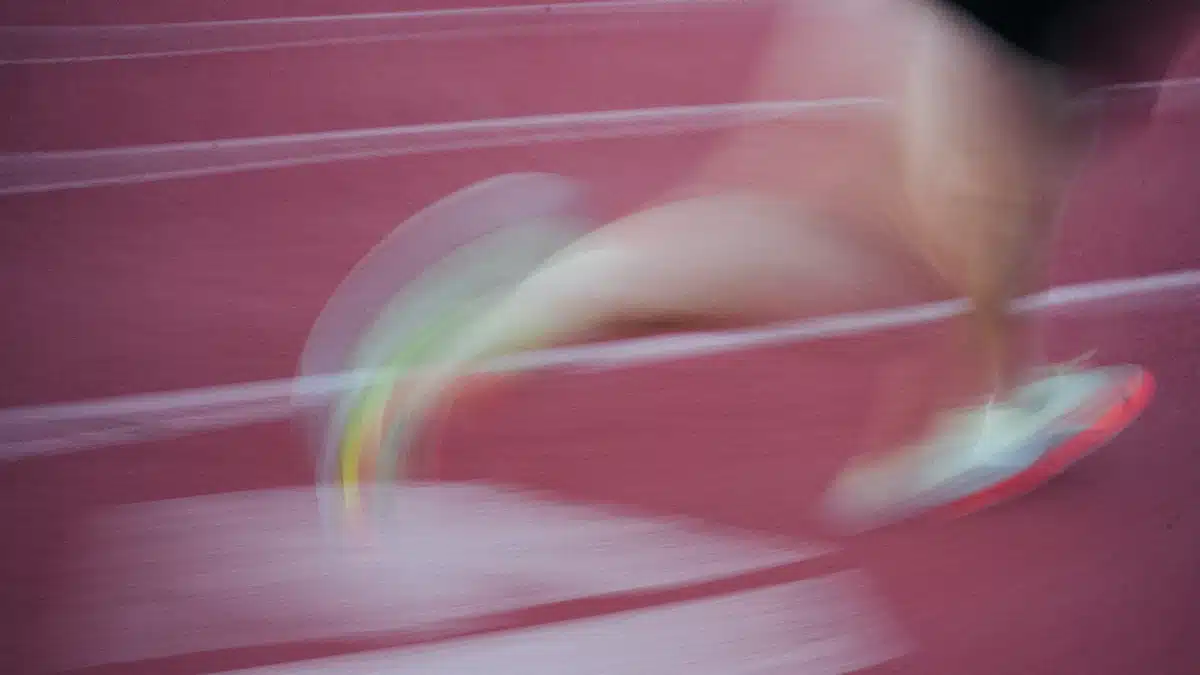 Detalle de corredor entrenando sobre pista para mejorar su resistencia