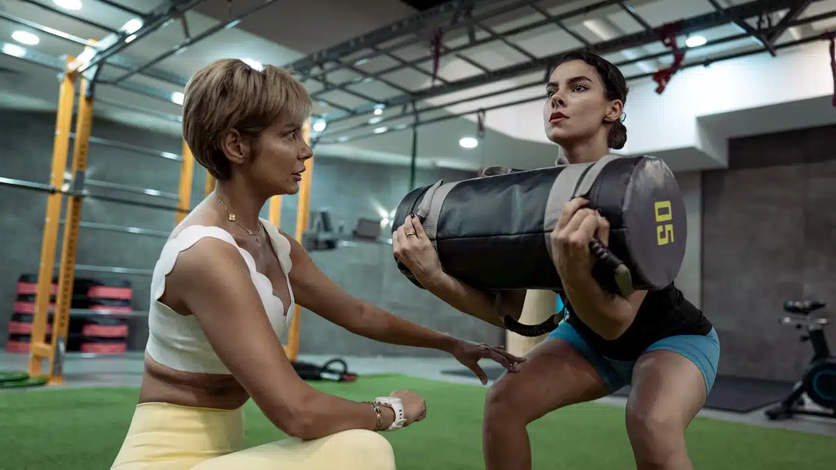 Dos deportistas ejecutando sentadillas con supervisión en un espacio de entrenamiento