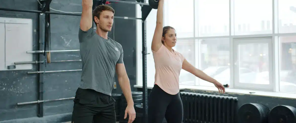 Dos deportistas entrenan fuerza con kettlebells en un gimnasio moderno