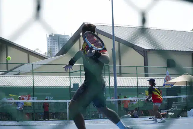Dos jugadores de tenis durante una acción en una pista exterior