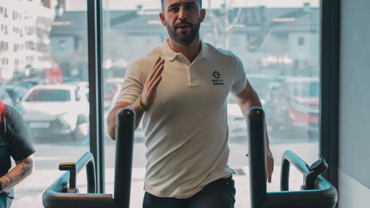 Entrenador supervisa a un deportista junto a una cinta de correr