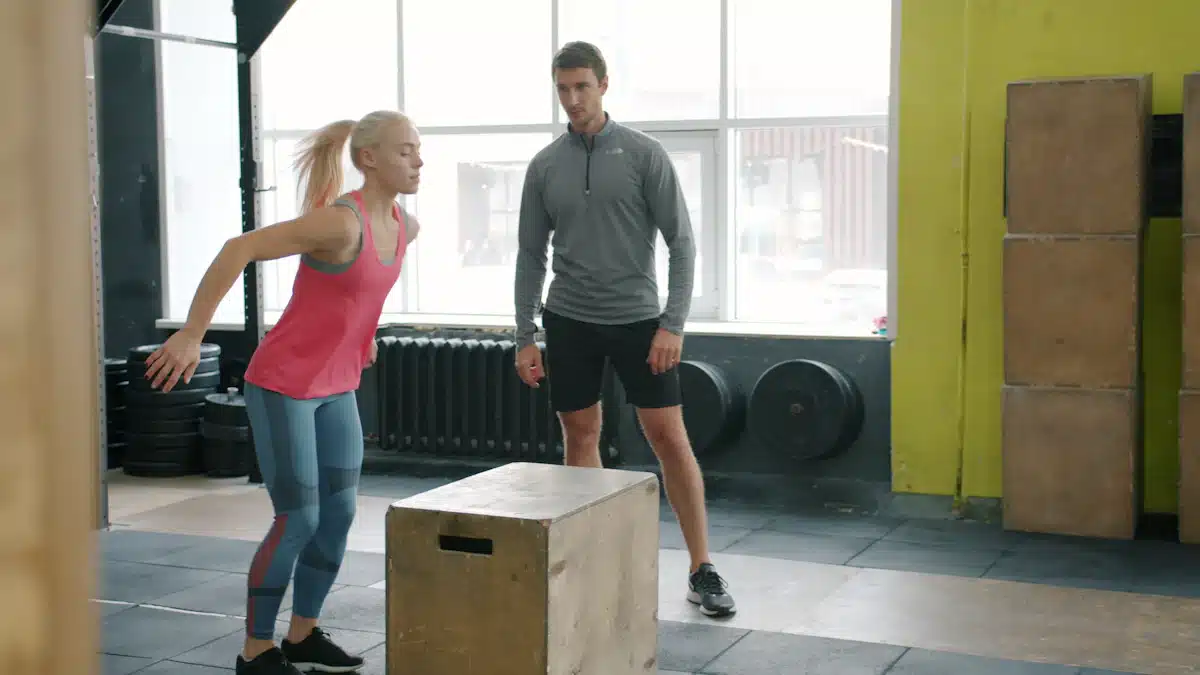 Atleta realiza un ejercicio de pliometría al cajón supervisada por su entrenador