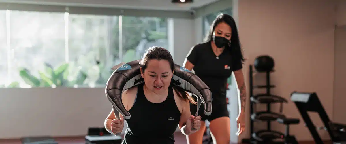 Entrenadora supervisa una zancada durante una sesión de ejercicio