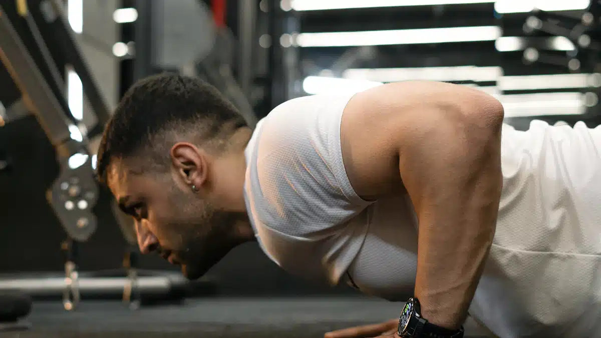 Hombre ejecutando flexiones controladas sobre el suelo de un gimnasio deportivo