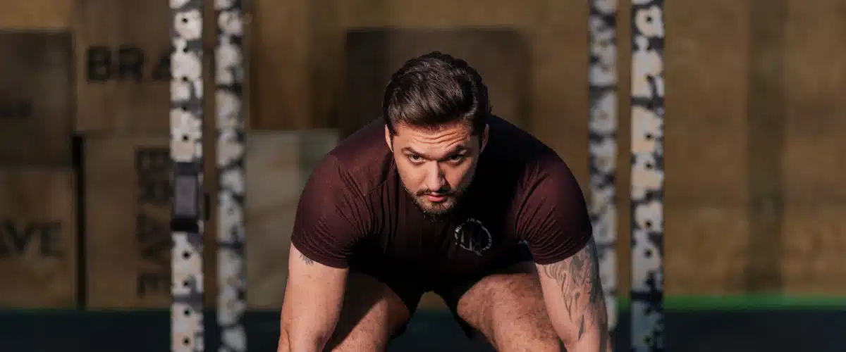 Hombre eleva una barra pesada durante una sesión de musculación