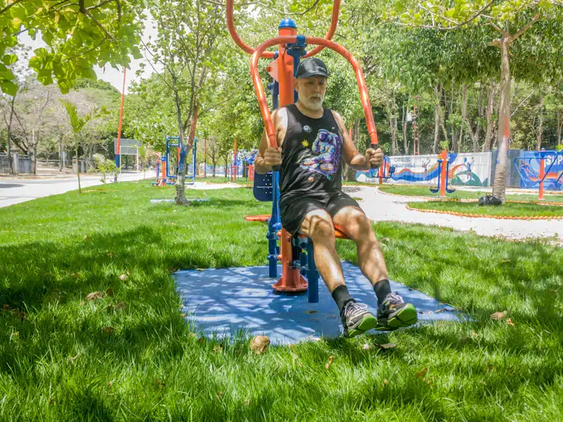 Hombre mayor realizando press de pecho en un gimnasio exterior