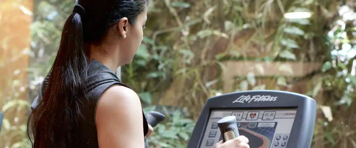 Mujer entrenando con máquina de fuerza en un gimnasio moderno