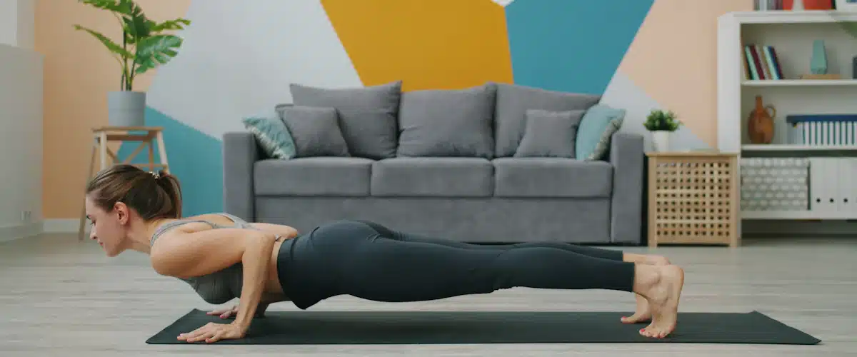 Mujer realizando flexiones sobre una esterilla en el interior de casa