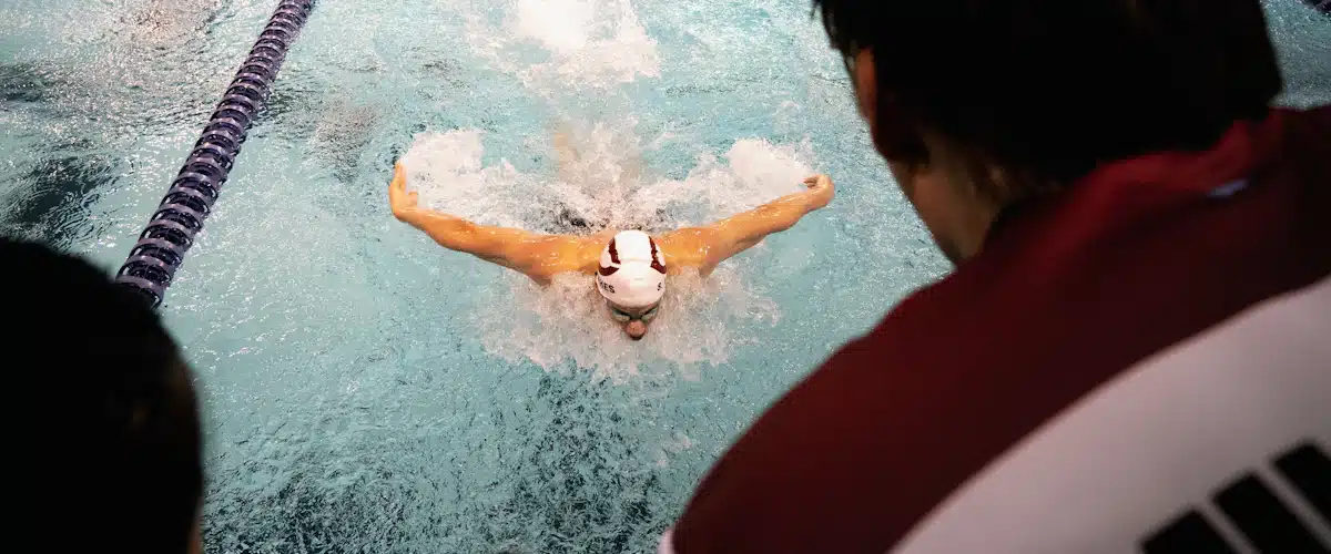 Nadador realizando mariposa durante una sesión exigente de entrenamiento en piscina