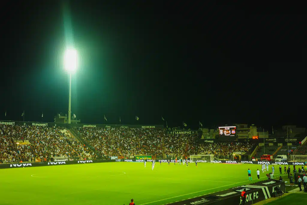 Partido de fútbol en un estadio iluminado con espectadores