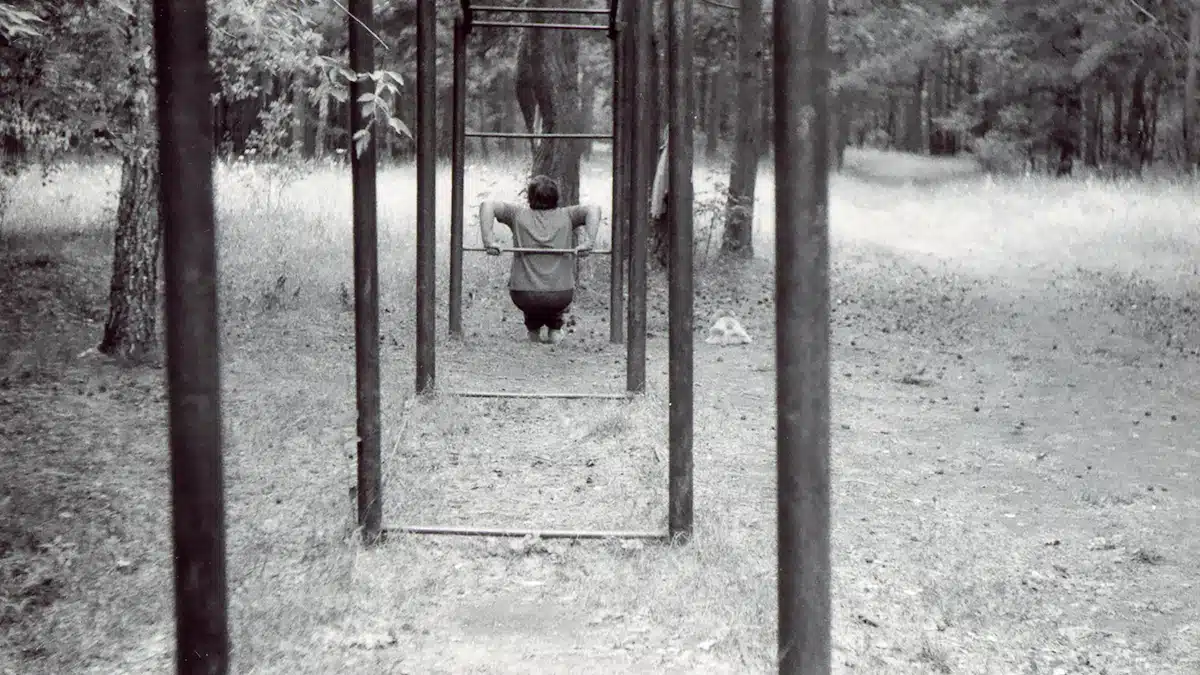 Persona practicando suspensión en una estructura de barras al aire libre