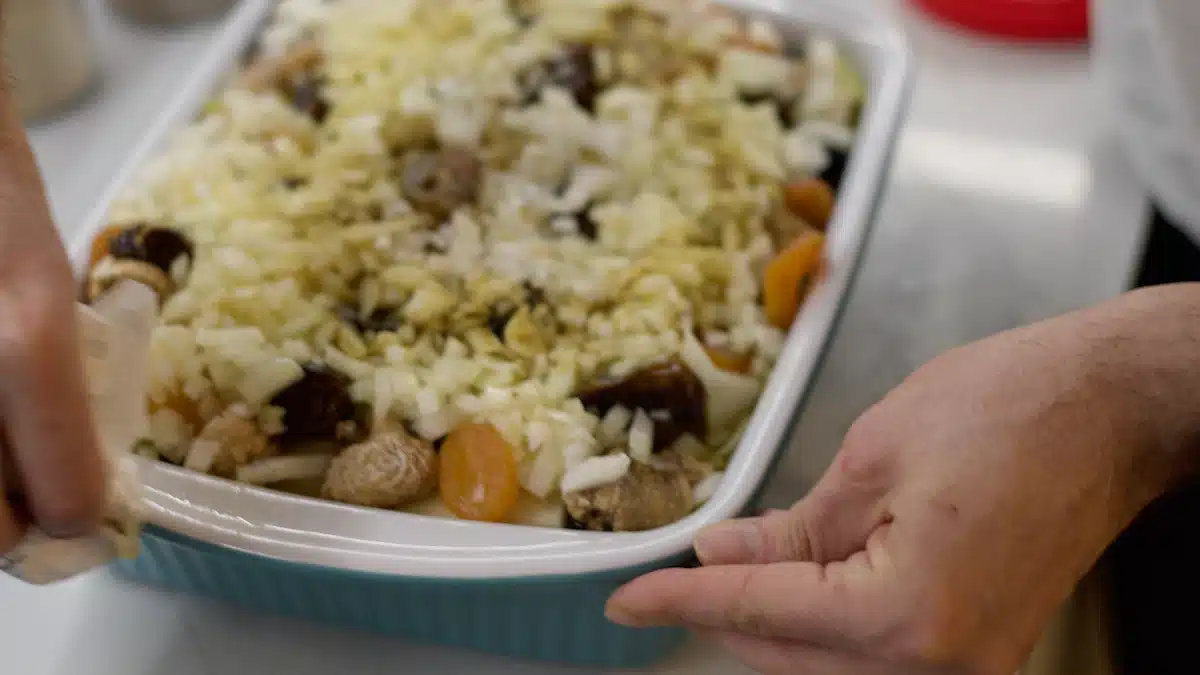 Persona preparando una ración de pollo y verduras en un recipiente