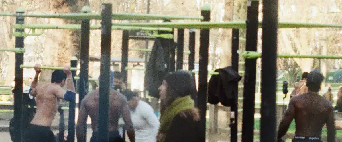 Personas practican ejercicios de calistenia en barras de un parque