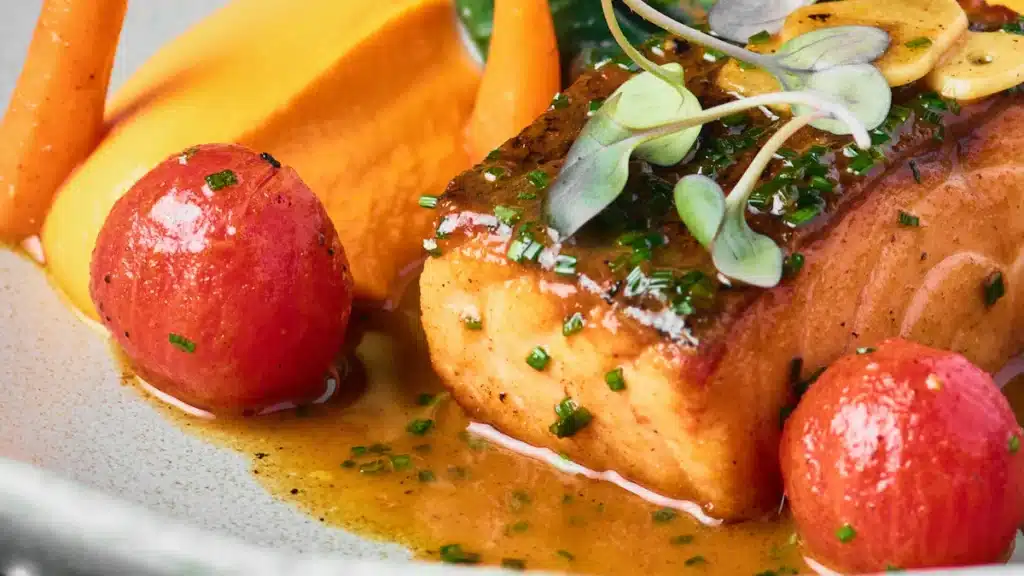 Plato de salmón con verduras, ejemplo de alimento que aporta taurina